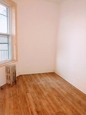 Chicago apartment for rent - A room with a window and a radiator on the floor.