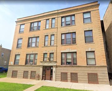 Chicago apartment for rent - A brown building with a green lawn in front.
