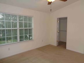 Orange Park house for rent - an empty living room with a large window and a door to a closet