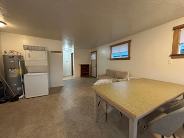 Sitka house for rent - A kitchen area with a refrigerator, oven, and a table with chairs.