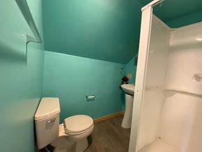 Sitka house for rent - A white toilet sits in a bathroom with a blue wall.