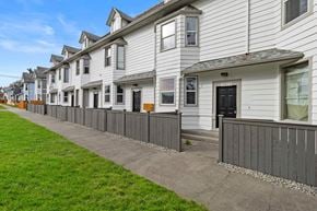 Tacoma apartment for rent - a row of white houses with a sidewalk and grass