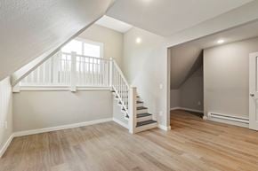 Tacoma apartment for rent - the living room and entryway of a house with white stairs and wood floors