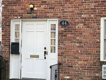 Port Washington apartment for rent - A white door with a mailbox and a number 44 on the brick wall.