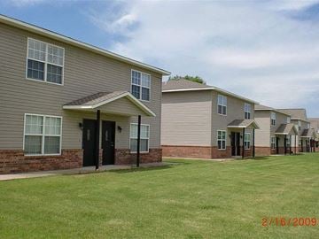 Stillwater house for rent - a row of houses with a green lawn