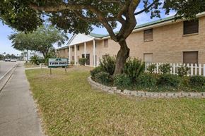 Slidell apartment for rent - a building with a street sign in front of a tree