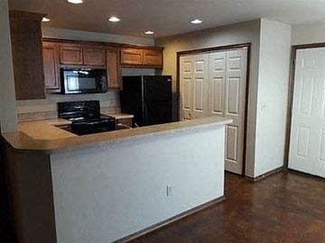 Stillwater house for rent - A kitchen with a black refrigerator and stove.