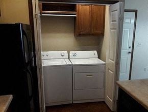 Stillwater house for rent - A black refrigerator is on the left of a white dishwasher and stove.