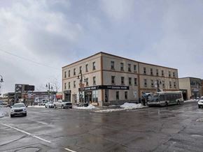 Oshawa apartment for rent - a building on a city street with cars and a bus