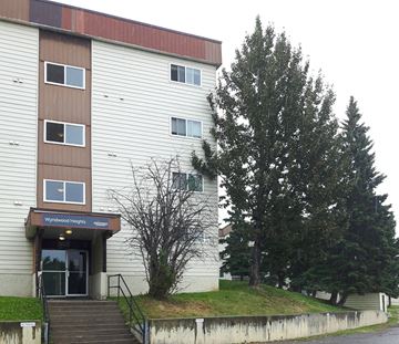 Chetwynd apartment for rent - a building with stairs and a tree in front of it