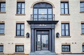 Oshawa apartment for rent - a white brick building with a black door and a balcony