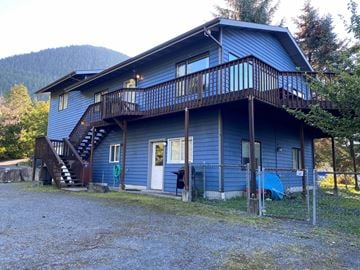 Sitka apartment for rent - A blue house with a balcony and a staircase leading to the second floor.