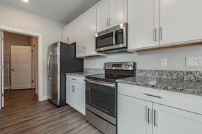 Tampa apartment for rent - a kitchen with stainless steel appliances and white cabinets