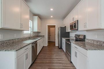 Tampa apartment for rent - a kitchen with white cabinets and granite counter tops