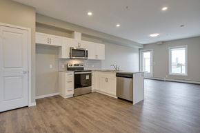 Edmonton apartment for rent - an empty kitchen with white cabinets and stainless steel appliances