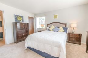 Ballwin apartment for rent - a bedroom with a bed and a dresser and a window