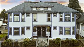 Tacoma apartment for rent - a white house with a gray roof and a fence
