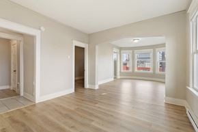 Tacoma apartment for rent - a living room and dining room with white walls and wood floors