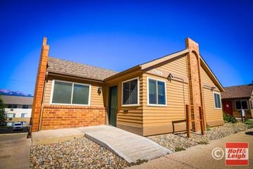 Colorado Springs apartment for rent - A house with a brown siding and a green door is shown.