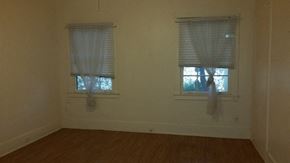 Phoenix apartment for rent - an empty room with two windows and a wooden floor