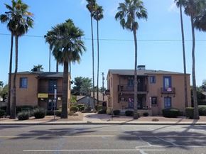 Phoenix apartment for rent - a building with palm trees in front of it on a street