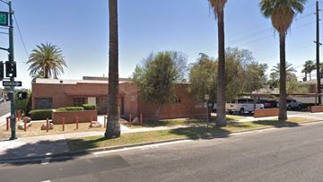 Phoenix apartment for rent - a red brick building with palm trees in front of it