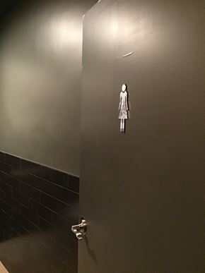 Phoenix apartment for rent - a bathroom stall with a statue of a woman on the wall