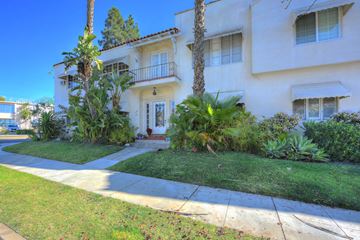 Los Angeles apartment for rent - the front of a white house with a lawn and palm trees