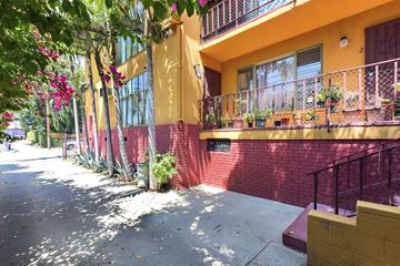 Los Angeles apartment for rent - A yellow building with a red wall and a balcony.