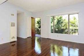 Los Angeles apartment for rent - A room with wooden floors and a large window overlooking a green landscape.