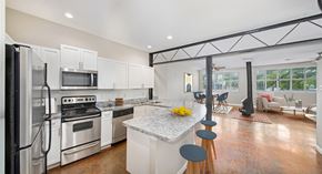 Dallas apartment for rent - a kitchen with white cabinets and a marble counter top