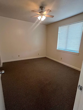 Laredo apartment for rent - A room with a ceiling fan and a window with blinds.