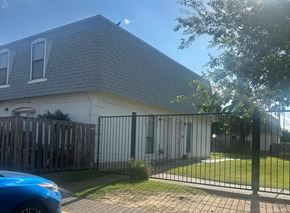 Laredo apartment for rent - a house with a fence and a blue car in front of it