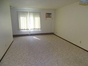 Rugby apartment for rent - an empty living room with a window and white walls