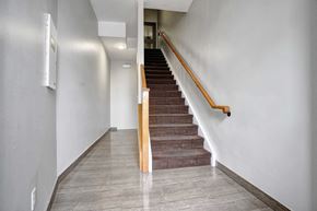 Oshawa apartment for rent - a flight of stairs with a wooden railing and white walls