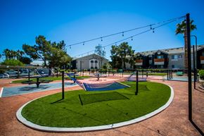 Las Vegas apartment for rent - A playground with a blue slide and a green lawn.