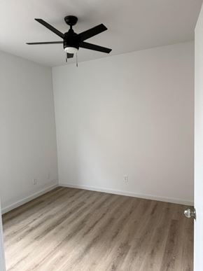 Laredo apartment for rent - A room with a ceiling fan and wooden flooring.