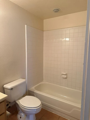 Laredo apartment for rent - A white toilet and bathtub in a bathroom with white tiles.