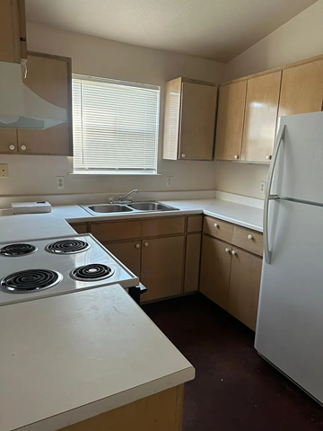 Laredo apartment for rent - A kitchen with a white stove top oven and a white refrigerator.