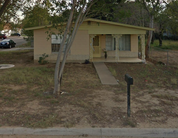 Laredo house for rent - a small yellow house with a tree in front of it