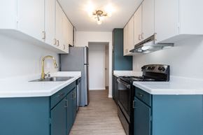 San Francisco apartment for rent - A kitchen with white cabinets and a black stove top oven.