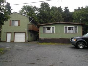 Sitka apartment for rent - a car parked in front of a green house