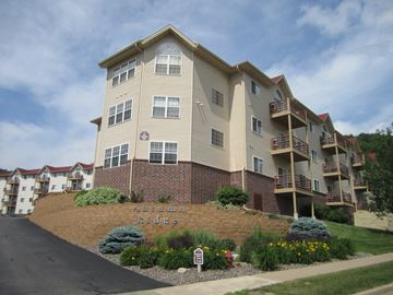 Eau Claire apartment for rent - an apartment building on a hill with a garden in front of it