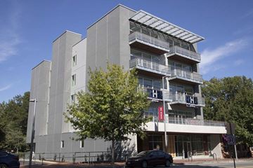 Raleigh apartment for rent - A modern building with a glass balcony on the second floor.