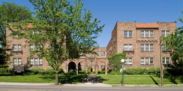 Cincinnati apartment for rent - A large brick building with a tree in front.