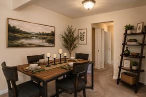 Glen Burnie apartment for rent - A dining room with a wooden table set for two.