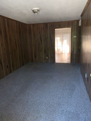 Kernersville apartment for rent - A room with wooden walls and a carpeted floor.