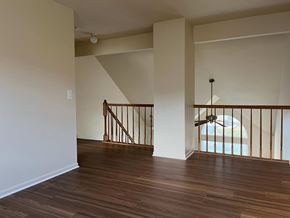 Gurnee apartment for rent - A room with wooden floors and a staircase with a railing.