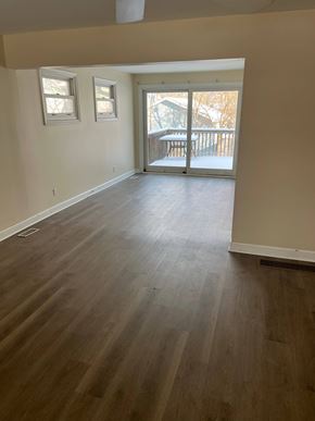 Grayslake apartment for rent - A room with wooden flooring and a sliding glass door.