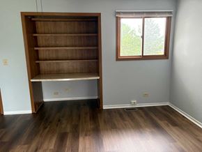 Gurnee apartment for rent - A room with a large wooden bookshelf and a window.